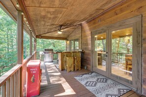 A wooden deck with a grill, a Coca-Cola cooler, and a patterned rug. - Hot Tub & Game Room! Spacious Blue Ridge Cabin (Blue Ridge)