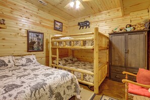 Ein Etagenbett mit Waldmotiv, ein Holzschrank und ein Willkommensschild.