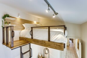 A bunk bed with a wooden ladder and a headboard with built-in lighting. - Walk to RiNo & Coors Field! Modern Denver Home (Denver)