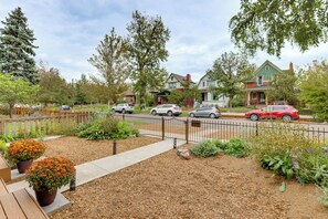 A residential street with houses, parked cars, and a garden with mulch and plants. - Walk to RiNo & Coors Field! Modern Denver Home (Denver)