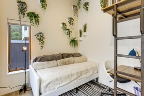 A modern room with a bed, a desk, and multiple hanging plants. - Walk to RiNo & Coors Field! Modern Denver Home (Denver)