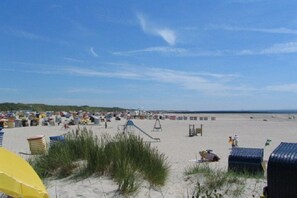 Een strand met vele strandhutten en een heldere lucht.