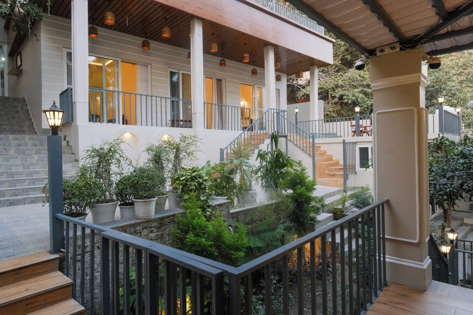 A multi-level outdoor area with a wooden deck, stone steps, and potted plants.