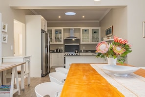 A modern kitchen with white cabinets, stainless steel appliances, and a central island. - Cloud 7 | Peaceful | Mountain & sea views | Onrus (Onrusrivier)