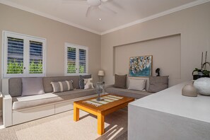 A living room with a sofa, coffee table, and artwork on the wall. - Cloud 7 | Peaceful | Mountain & sea views | Onrus (Onrusrivier)