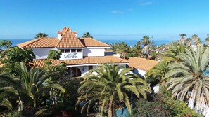 A two-story building with a sign reading 'Isla Verde' and a view of the ocean. - Isla Verde (Arona)