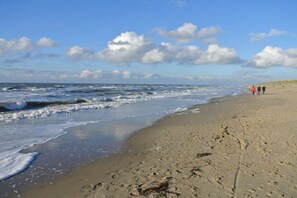 A beach with waves, footprints, and a clear sky. - Holiday home with 2 bedrooms (Julianadorp)
