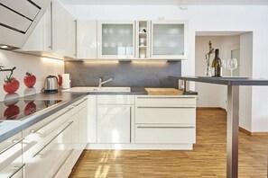 Eine moderne Küche mit weißen Schränken, einer Edelstahl-Spüle und einer Holz Arbeitsplatte.
