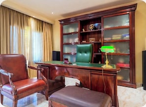 A room with a wooden desk, leather chair, and a green cushioned bench. - Luxury Villa in Corfu with Indoor jaccuzi 15 min walk to town - Villa Foni Corfu (Kerkira)