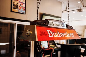 Een hangend bord met het Budweiser logo, een decoratief embleem en een design in vintage stijl.