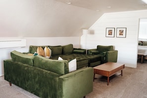 Een moderne woonkamer met een modulaire bank, een salontafel en een wandgemonteerde airconditioning.