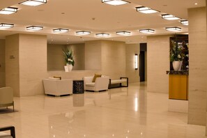 A spacious lobby with a reception desk, seating area, and modern lighting fixtures. - Auckland Above the Clouds 29th Floor Sea View (Auckland)