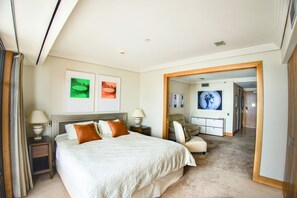 A hotel bedroom with a large bed, two bedside tables, a mirror, and artwork on the wall. - Auckland Above the Clouds 29th Floor Sea View (Auckland)