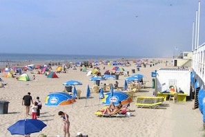A beach with tents, umbrellas, and beach chairs. - Holiday home with 2 bedrooms (Julianadorp aan Zee)