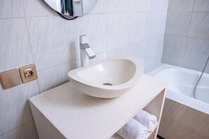 A bathroom with a white sink, a mirror, and a bathtub. - A tropical Bali villa with a private pool and peaceful vibes (Gianyar)