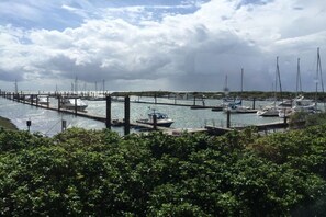 Een jachthaven met stilgelegde boten, omringd door groen.