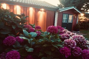 Ein Haus mit Holzausbau, einer dunklen Haustür und einem kleinen Vorbereich.