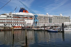 A large cruise ship docked at a marina with multiple decks and a prominent orange and white color scheme. - Holiday apartment with 1 bedroom (Cuxhaven)