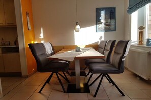 A dining area with a table, chairs, and a pendant light. - Residence Hohe Lith 1.02 (Cuxhaven - Duhnen)