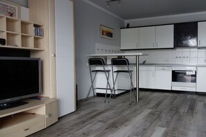 A modern kitchen with white cabinets, a black countertop, and a built-in oven. - 18 in the Stranddüne house (Haffkrug)