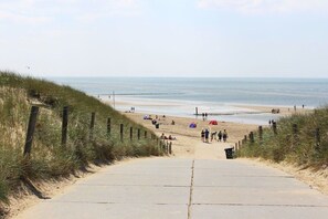 A beach pathway leading to the shore with people and tents. - Holiday apartment with 2 bedrooms (Julianadorp aan Zee)