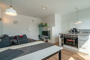 A compact living space with a dining area, kitchenette, and seating area. - in the Butenbörkumer house (Borkum)