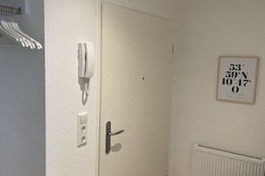 Een deur met een telefoon, een lichtschakelaar en een lijst met coördinaten.