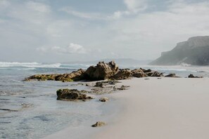 Una playa con afloramientos rocosos y una vista despejada del océano.