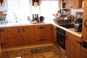 A kitchen with wooden cabinets, a stove, and a coffee maker. - Holiday home with 3 bedrooms (Willingen)