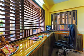 A room with a desk, computer monitors, a chair, and a window with blinds. - Hotel O Jayam Residency (Tirupati)
