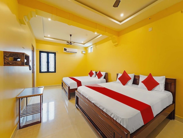 A hotel room with a large bed, two bedside tables, a ceiling fan, and an air conditioning unit. - Hotel O Jayam Residency (Tirupati)