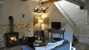 A cozy room with a fireplace, a television, and a comfortable seating area. - Holiday Home 'Numero 15' with Private Terrace, Private Garden and Wi-Fi (Autréville-Saint-Lambert)