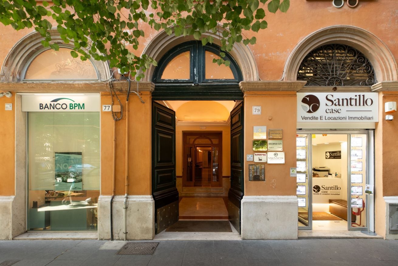 A building facade with a Banco BPM bank and a Santillo case real estate office.