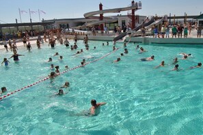 A swimming pool with multiple lanes and a water slide in the background. - Sigrid's Beach Warden III (Wurster Nordseeküste)
