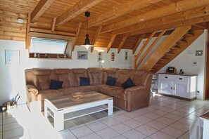 Ein Wohnzimmer mit Ecksofa, Couchtisch und Treppe.
