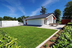 A single-story building with a flat roof, a small porch, and a well-maintained lawn. - Holiday home in Cuxhaven with swimming pool (Cuxhaven)