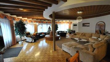 Una amplia sala de estar con suelo de madera, un gran sofá, una mesita de centro y una chimenea.