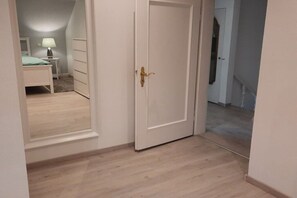 A room with a bed, a dresser, and a door with a brass handle. - Holiday home in Eichenzell with barbecue (Eichenzell)