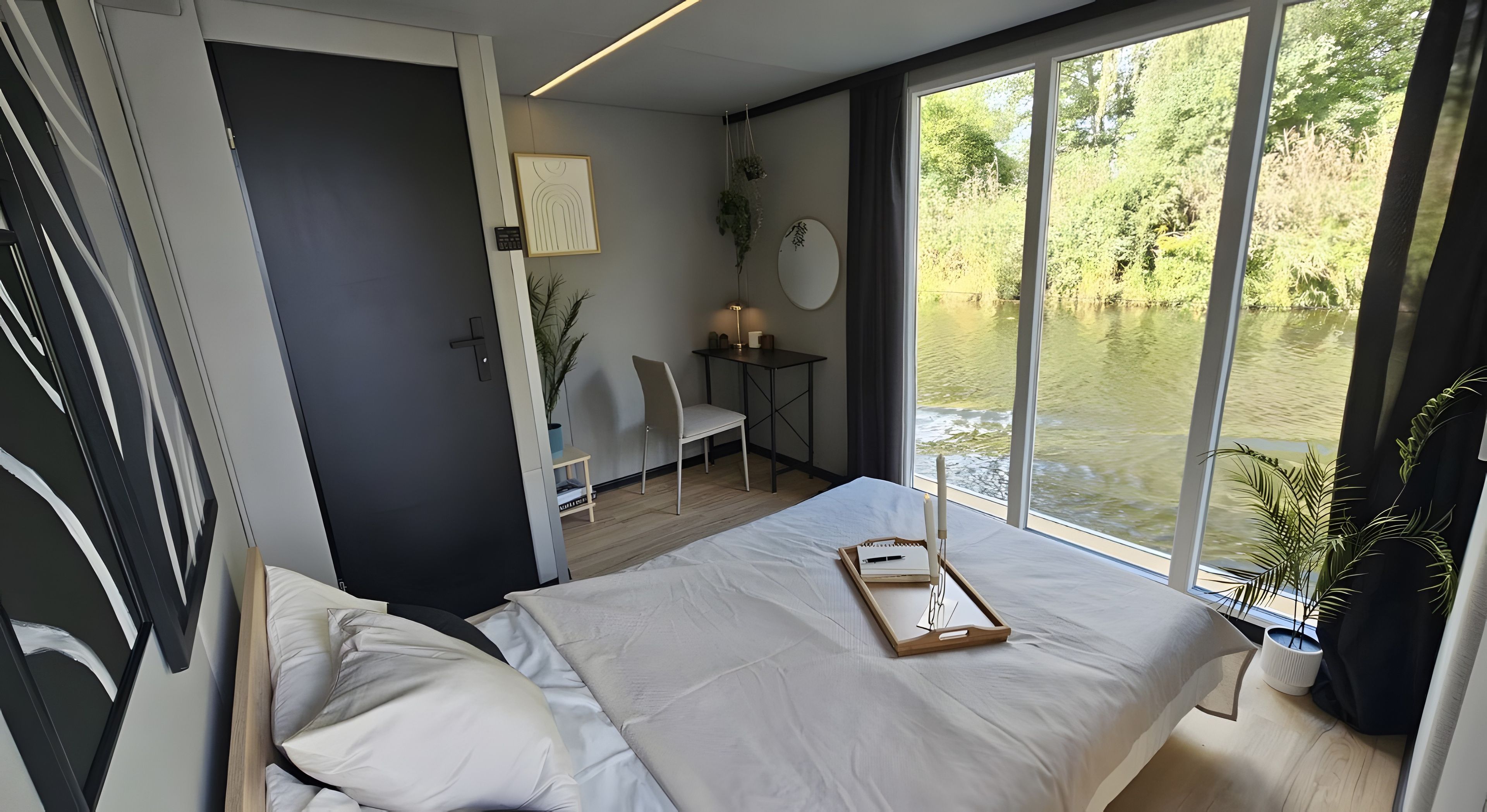 A modern bedroom with a large window, a bed, a desk, and a chair.