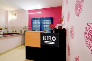 A hotel reception desk with a sign indicating it is OYO-Serviced.