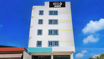 Edifício de um hotel com vários andares, com uma placa indicando que é administrado pela OYO.