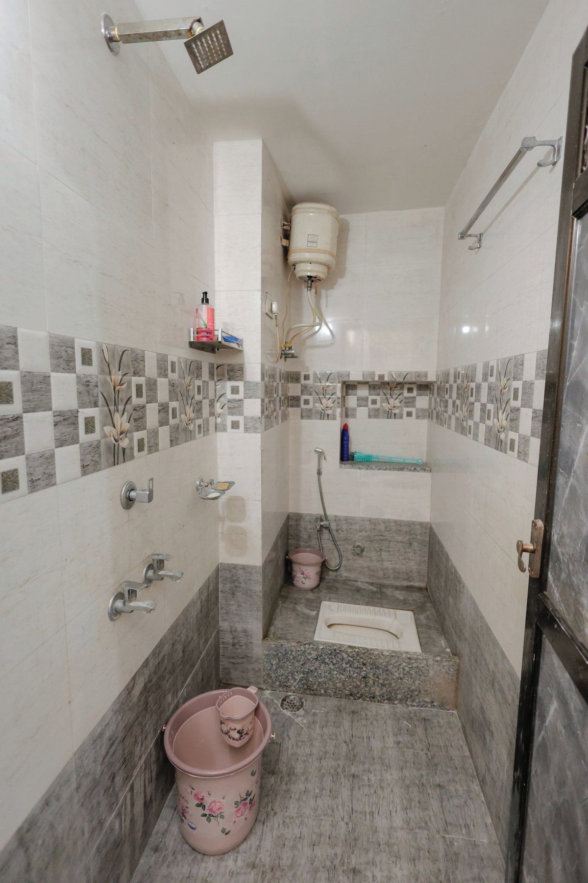 A bathroom with a shower, toilet, and sink, tiled with a checkered pattern.