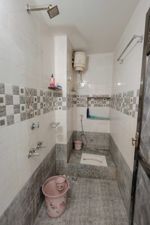 A bathroom with a shower, toilet, and sink, tiled with a checkered pattern. - The Jawai Niwas (Sumerpur)
