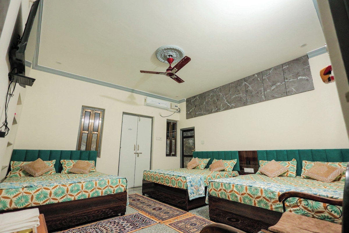 A hotel room with two beds, a ceiling fan, a large mirror, and a patterned wall.