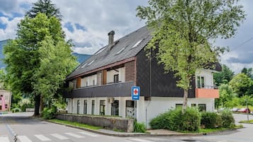 Ein Gebäude mit einem Schild für eine medizinische Einrichtung, einem Kreuz und einem Parkplatzzeichen.