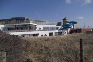 Ein modernes Gebäude mit Glasfassade, einem markanten Turm und einem Hubschrauberlandeplatz.