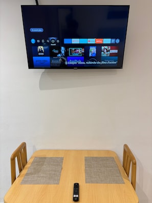 Un téléviseur à écran plat fixé au mur, affichant différentes plateformes de diffusion en continu.