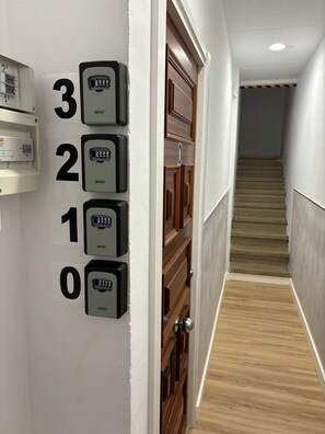 En gang med numerisk tastatur til dør og en trappe, der fører til en anden etage.