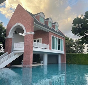 A house with a swimming pool, a brick facade, and a balcony. - Serene 2-bedroom House Rental in Bang Kaeo, Thailand (Bang Phli)