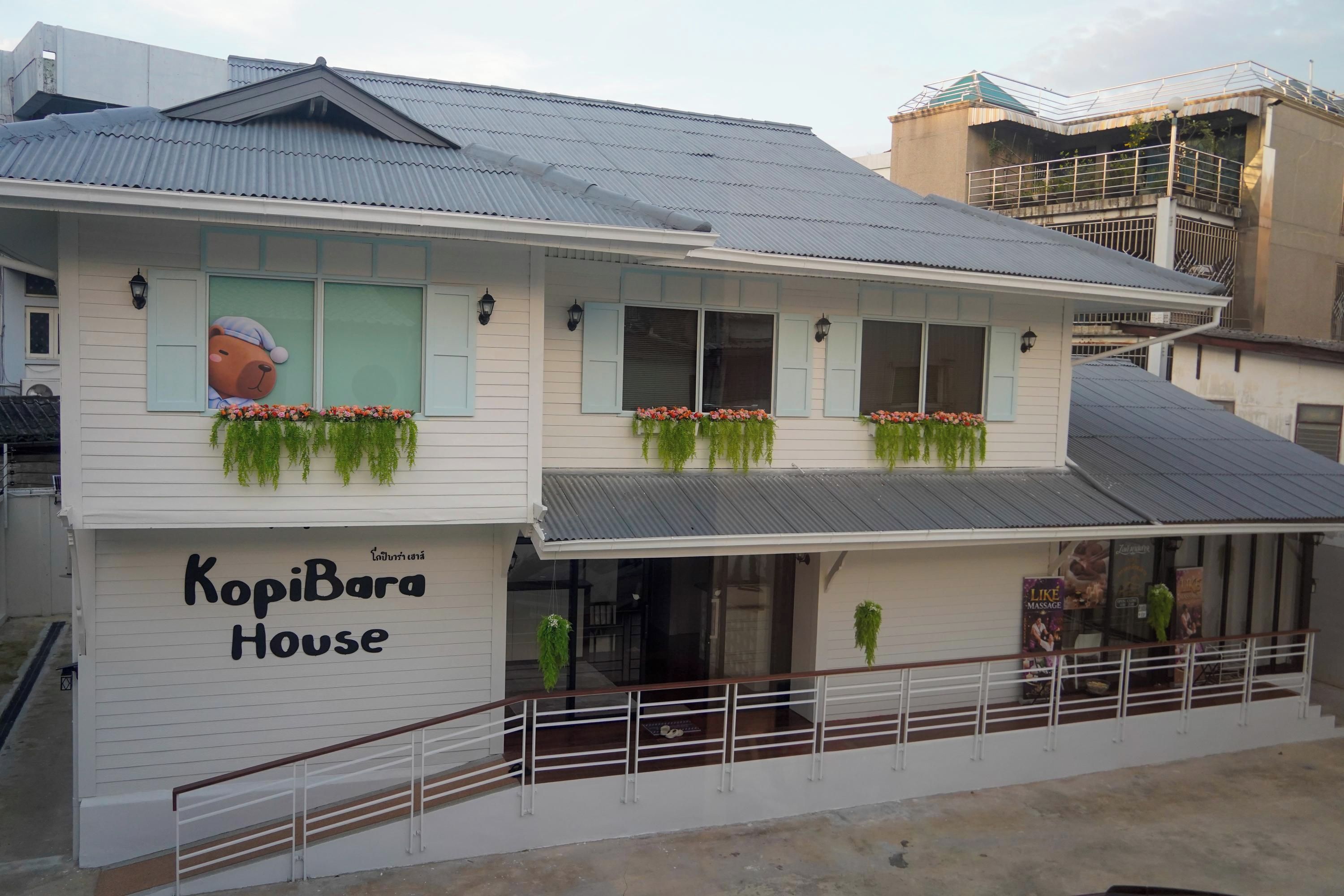 A two-story building with a sign reading 'KopiBara House.'